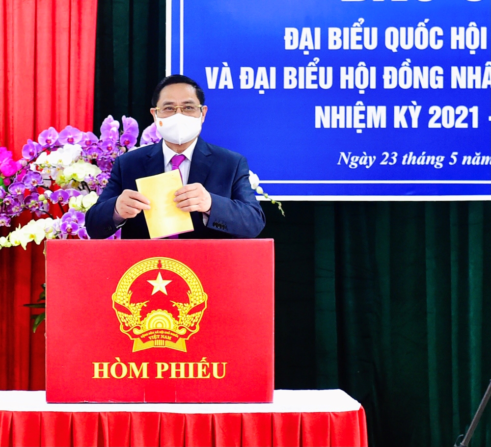 Thủ tướng Phạm Minh Chính là người bỏ lá phiếu đầu tiên vào hòm phiếu tại khu vực bỏ phiếu số 18. Ảnh: Trọng Hải